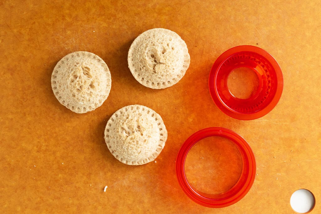 Sealing pizza uncrustables on cutting board.