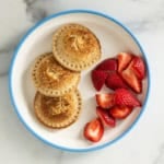 Pizza uncrustables on plate with strawberries.
