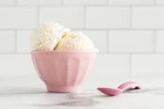 Vanilla frozen yogurt in pink dish.