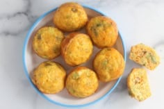 Broccoli muffins on plate with muffin cut open on side.