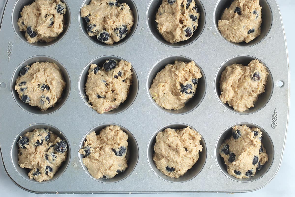 batter for lemon blueberry muffins in muffin tin.