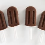 Chocolate popsicles on a white plate.