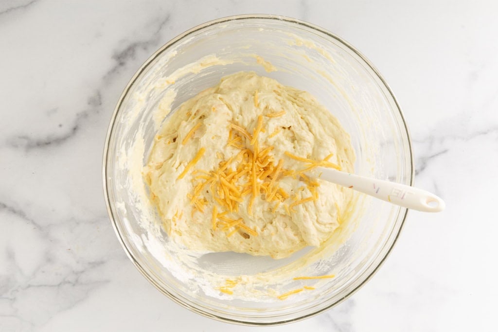 Batter for cheese muffins in glass bowl.