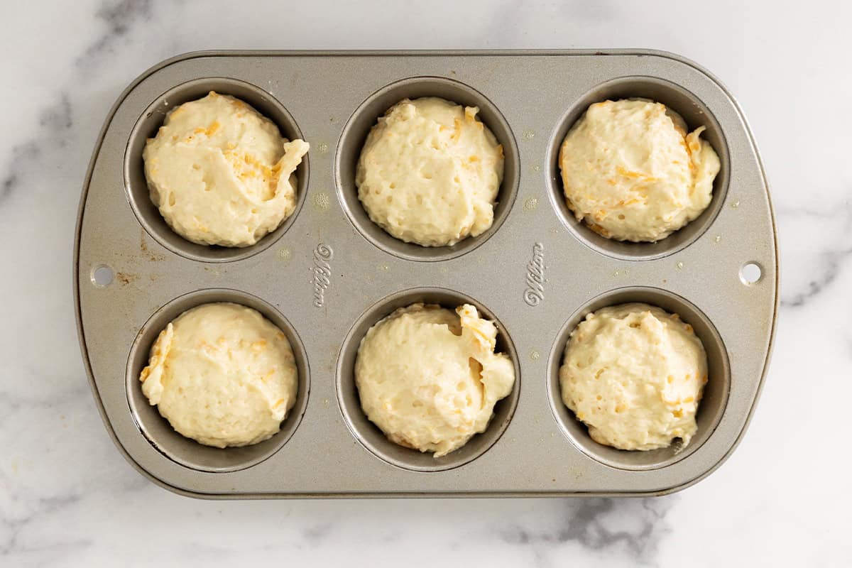 Cheese muffins in muffin pan before baking.