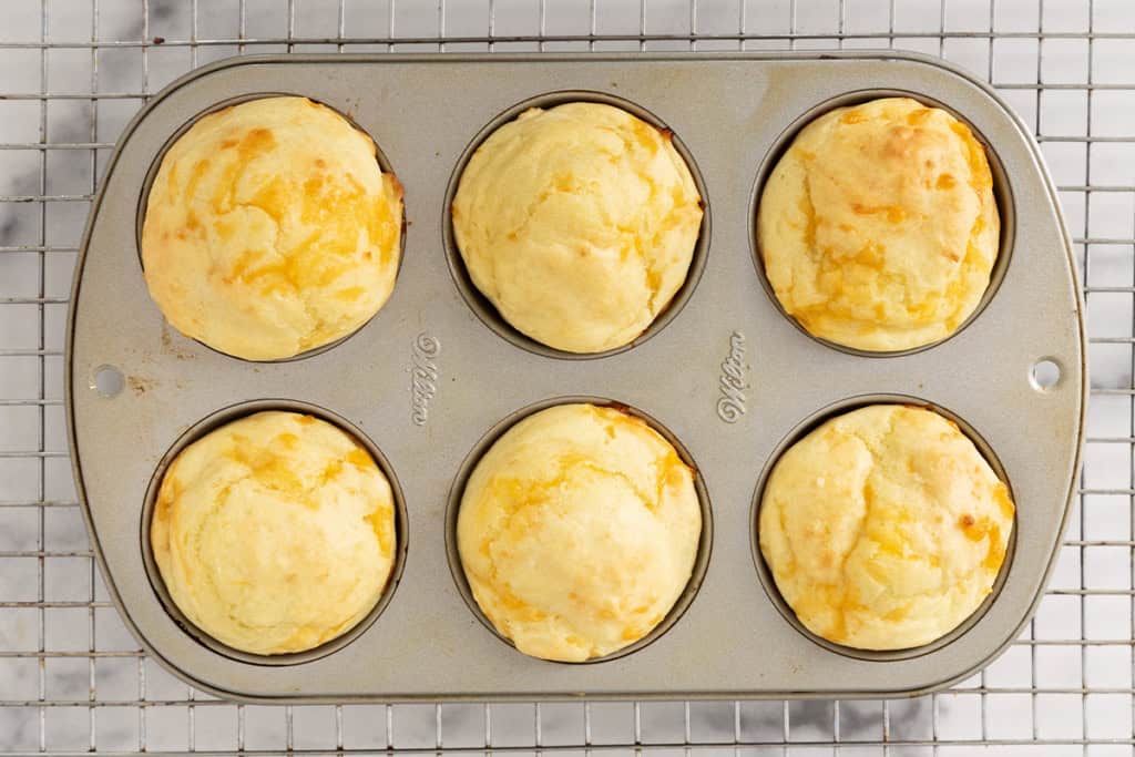 Cheese muffins in muffin pan after baking.