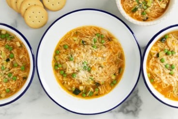 Vegetable noodle soup in bowls with sides.