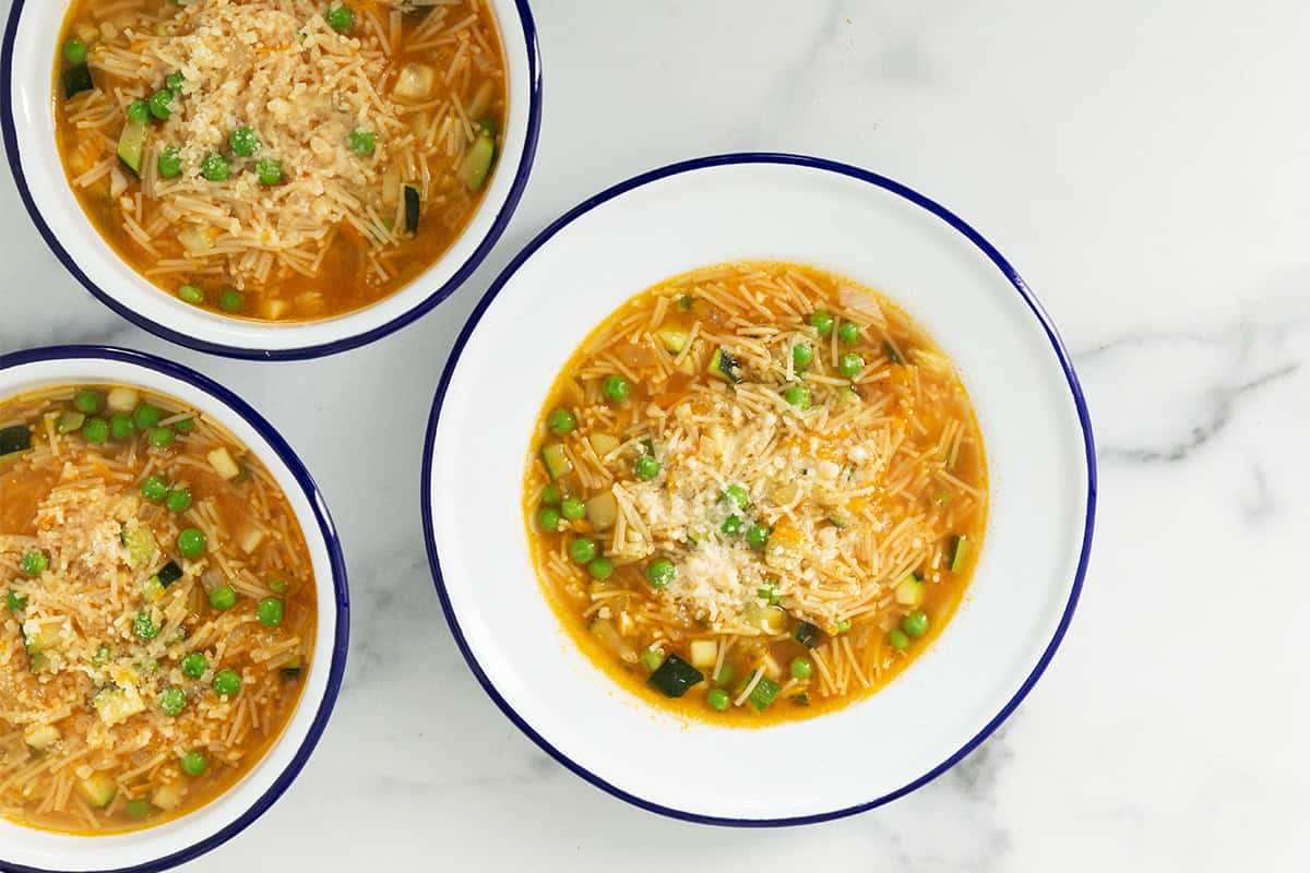 Vegetable noodle soup in three bowls.