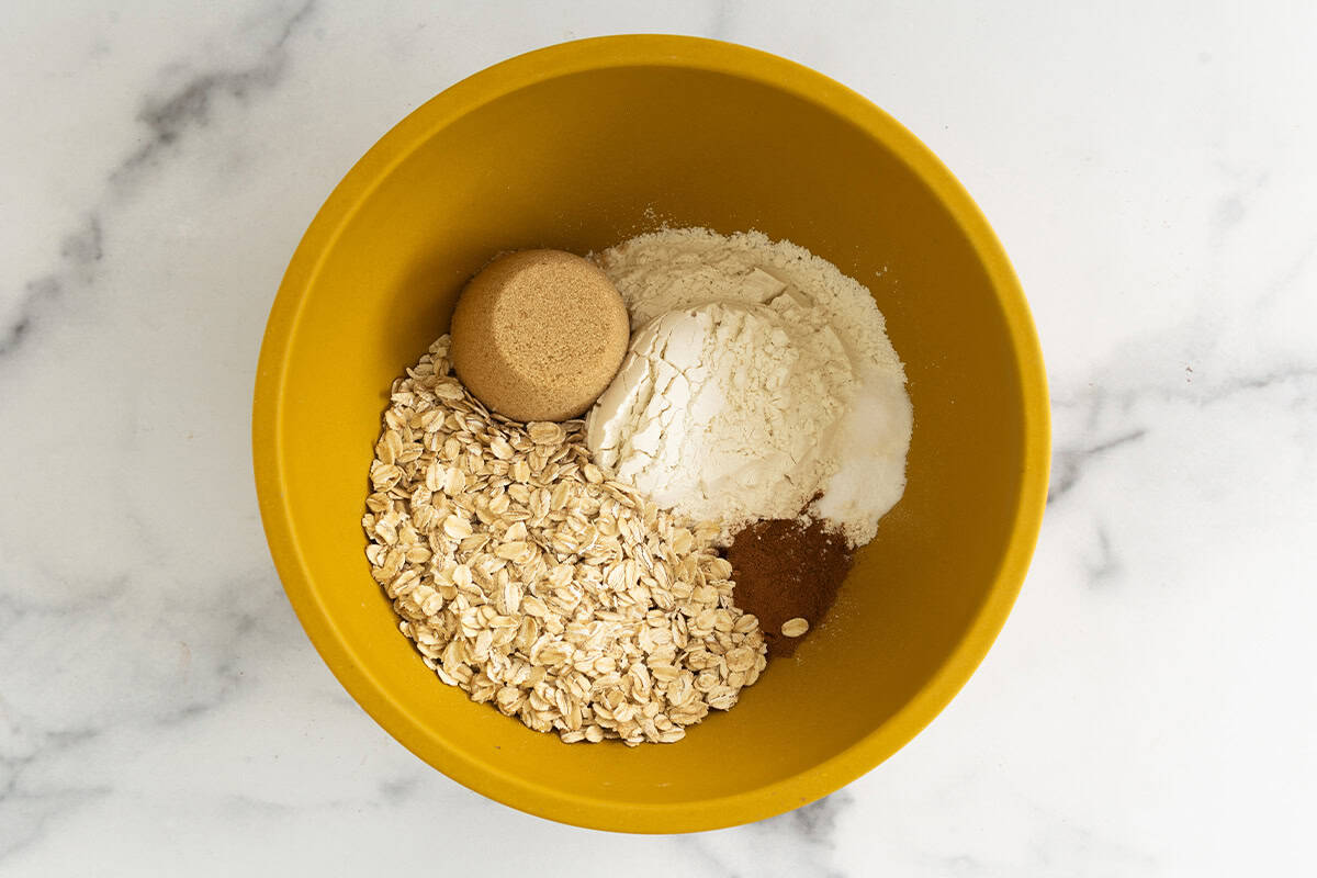 Ingredients for applesauce cookies in yellow bowl before mixing.