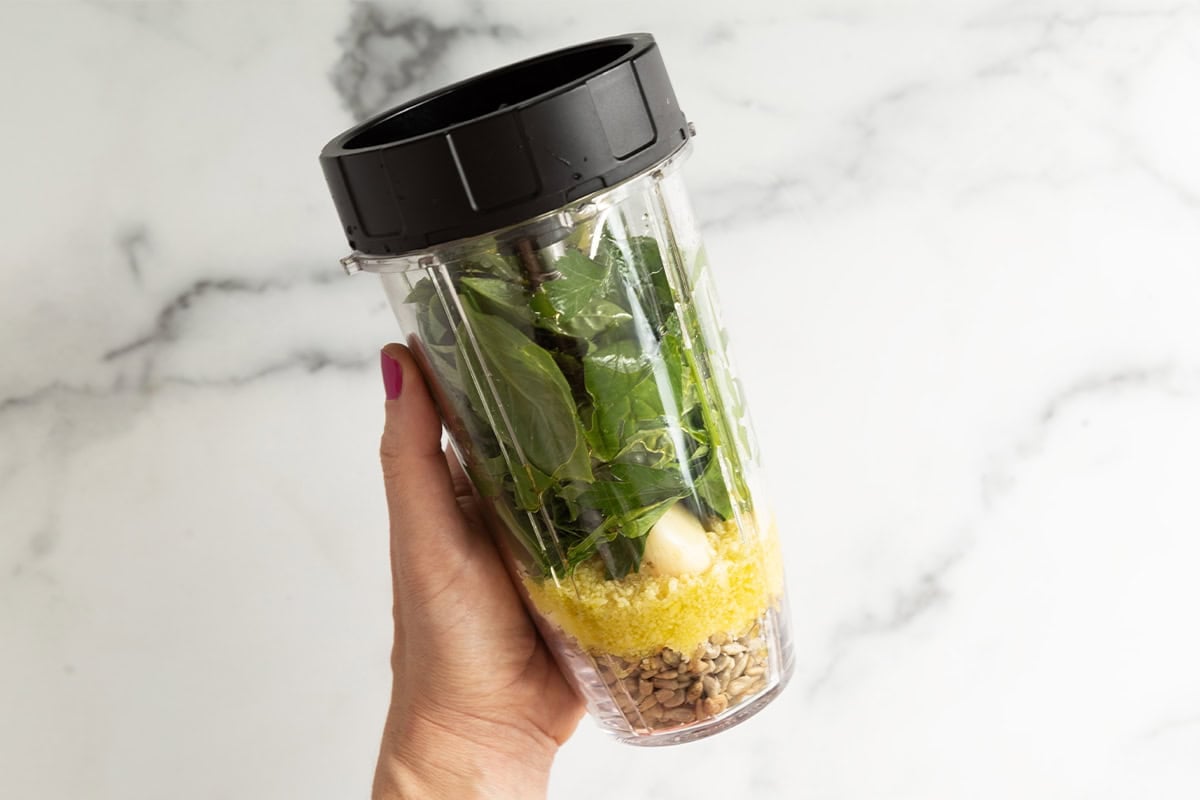 Ingredients for nut free pesto in a blender before blending.
