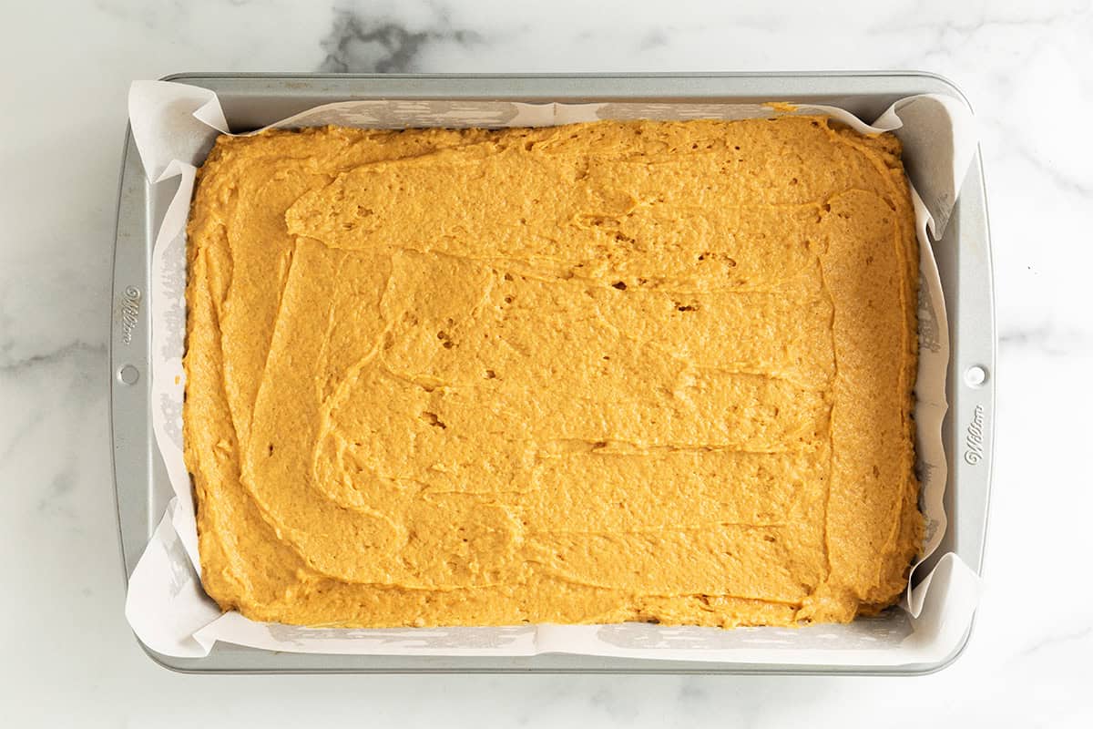 Batter for pumpkin bars spread into pan.