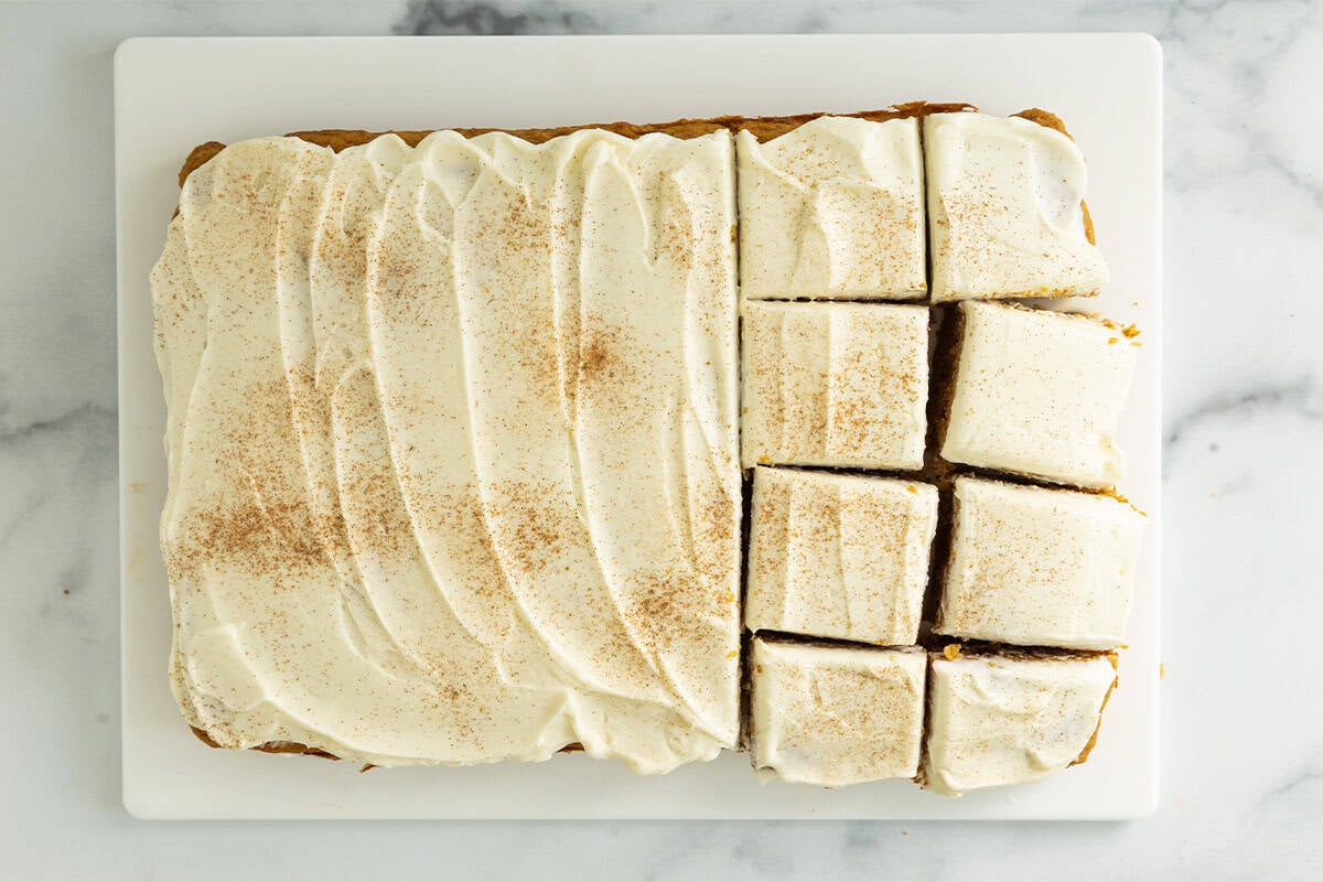 Pumpkin bars with frosting cut into squares.