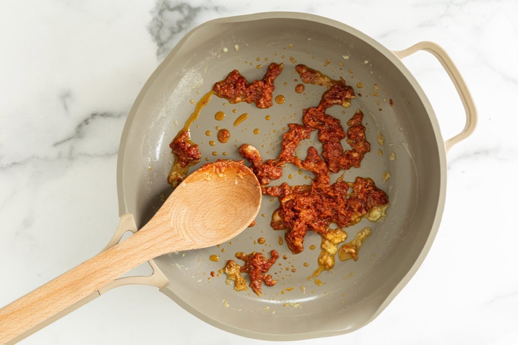 Tomatoes and garlic in frying pan for spaghettios.