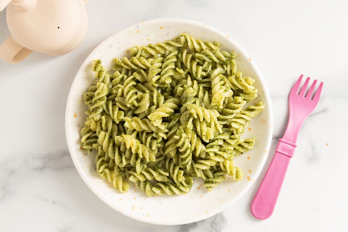 nut free pesto pasta on plate with pink form.