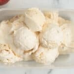scoops of fresh peach ice cream in container.