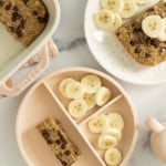 Banana bread baked oatmeal on two plates with banana slices.