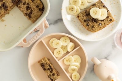 Banana bread baked oatmeal on two plates with banana slices.