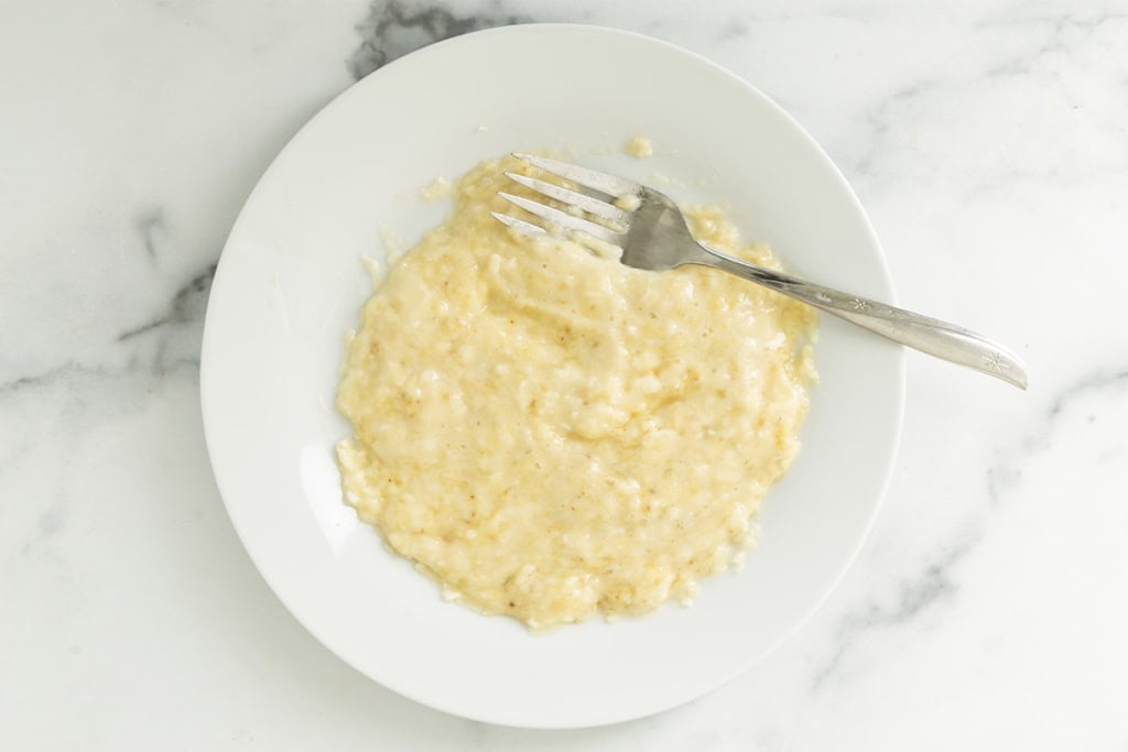 Banana mashed on plate for banana bread baked oatmeal.