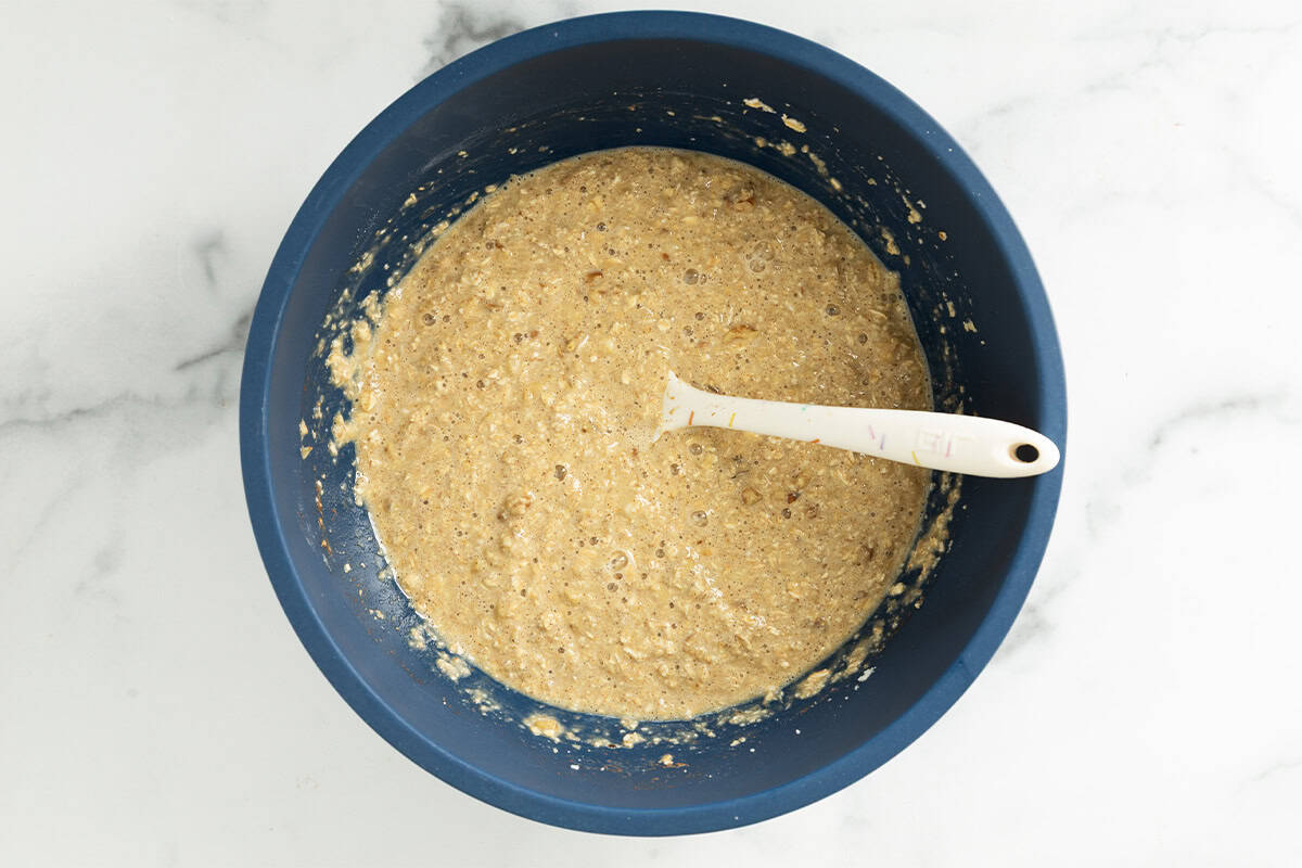 Batter for banana bread baked oatmeal in blue bowl.