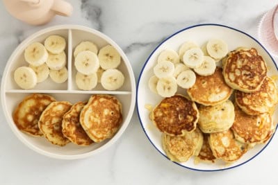 Banana yogurt pancakes on two plates with banana slices.