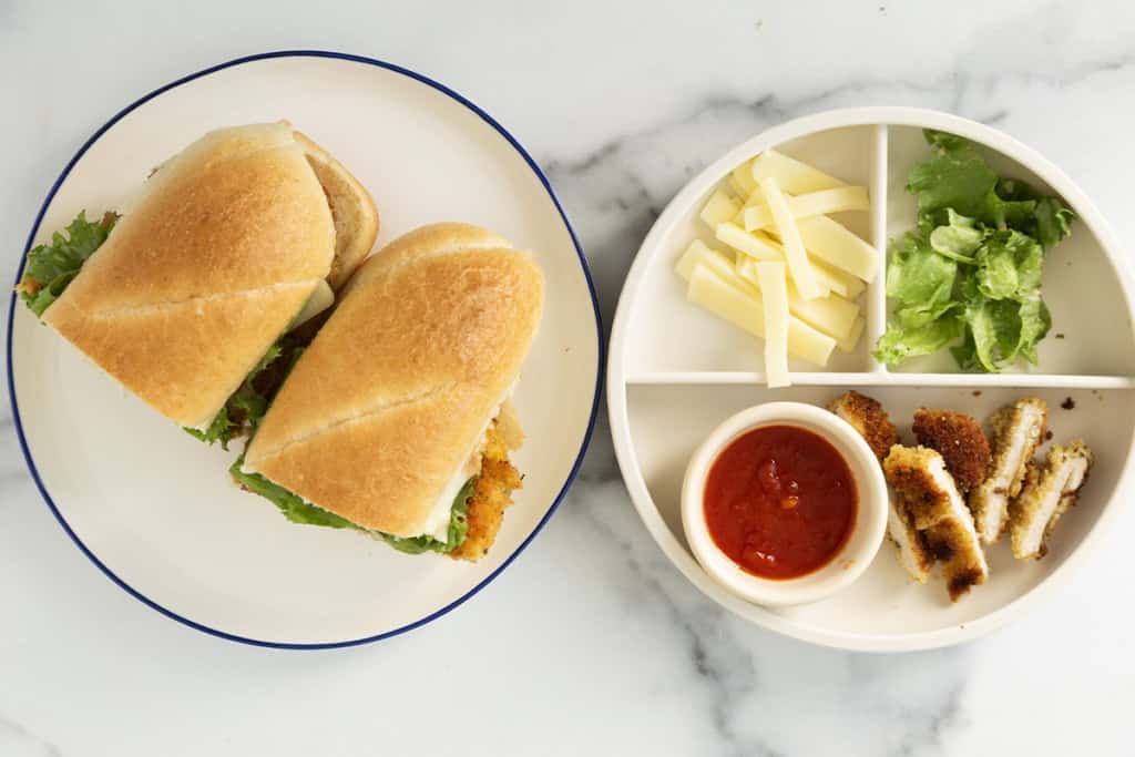 Chicken cutlet sandwich on plate with sides.