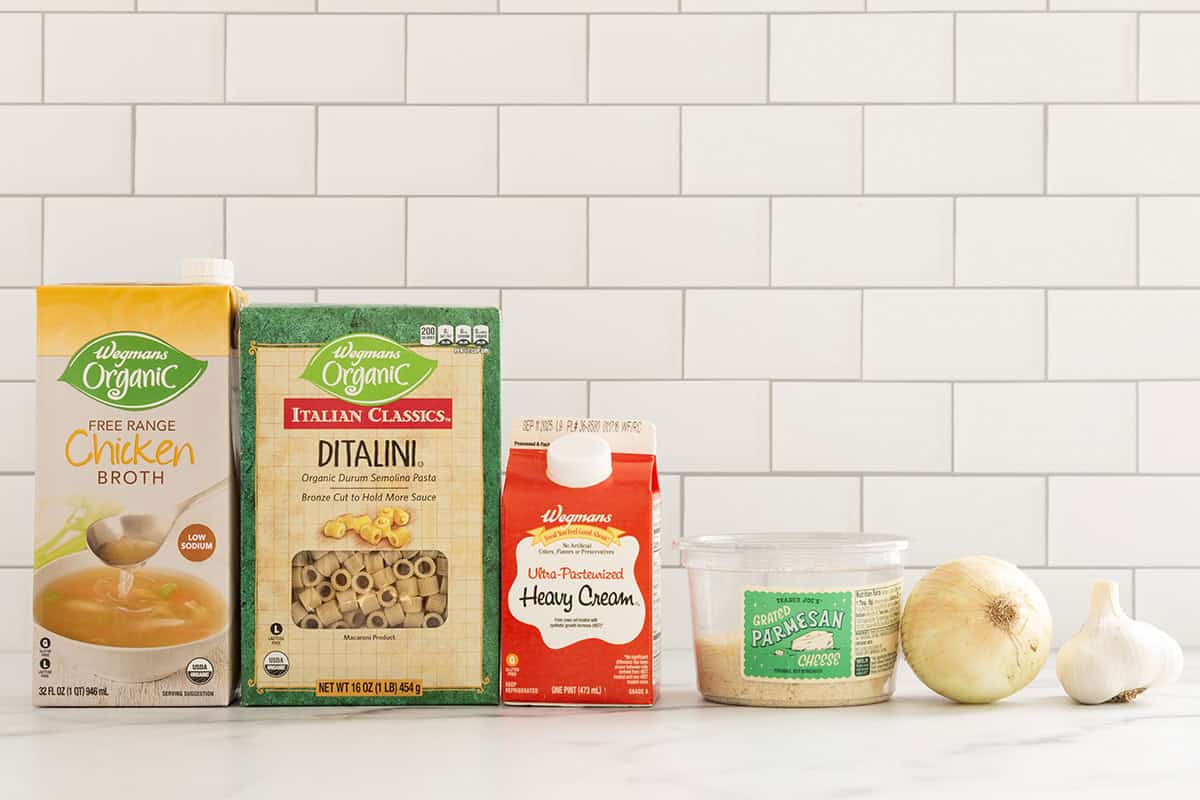 Ingredients for creamy pasta soup on countertop.
