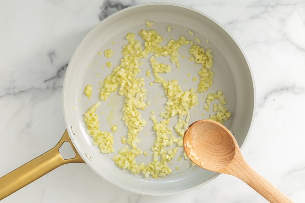 Onions in frying pan for creamy pasta soup.