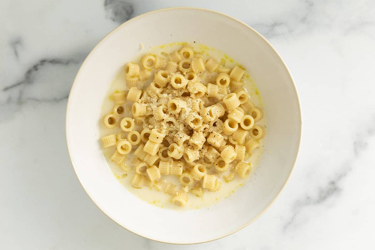 Creamy pasta soup in white bowl.