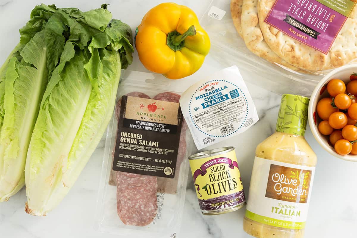 Ingredients for pizza salad on countertop.