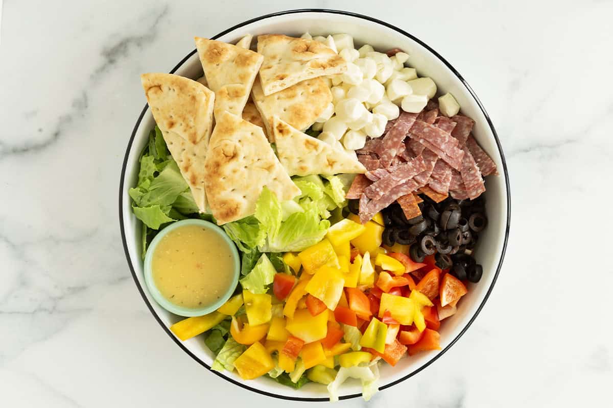 Pizza salad in bowl with dressing.