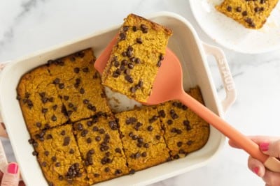 Spatula lifting piece of pumpkin baked oatmeal from pan.