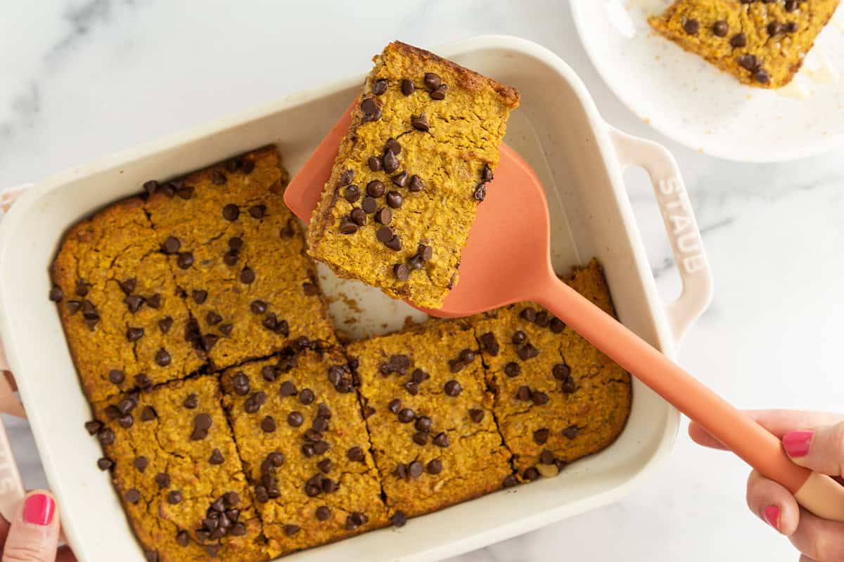 Spatula lifting piece of pumpkin baked oatmeal from pan.