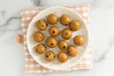 Pumpkin protein balls on white plate.