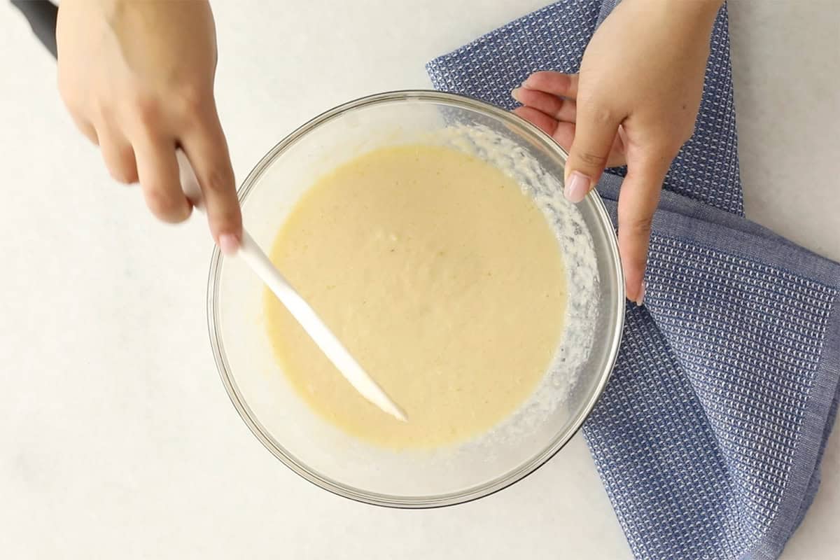 Mixing wet ingredients for applesauce muffins in glass bowl. 