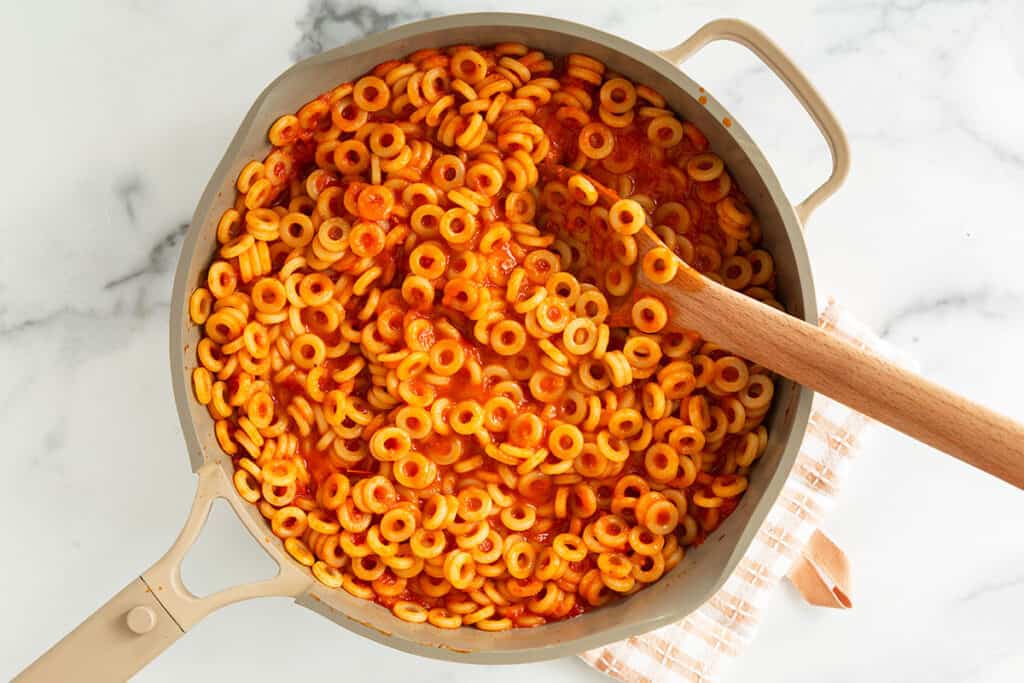 spaghettios in pan with wooden spoon.