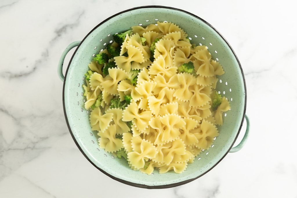 Pasta and broccoli in strainer.
