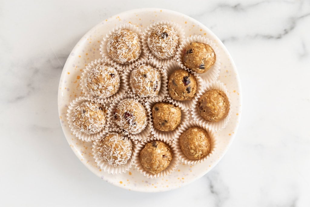 Almond butter protein balls on white plate.