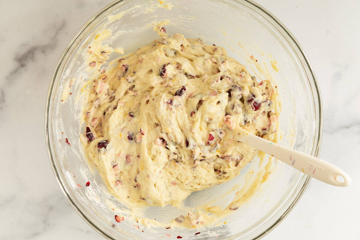 Batter in glass bowl for cranberry muffins.