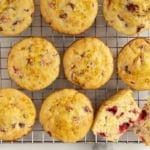 Cranberry muffins on cooling rack with one cut in half.