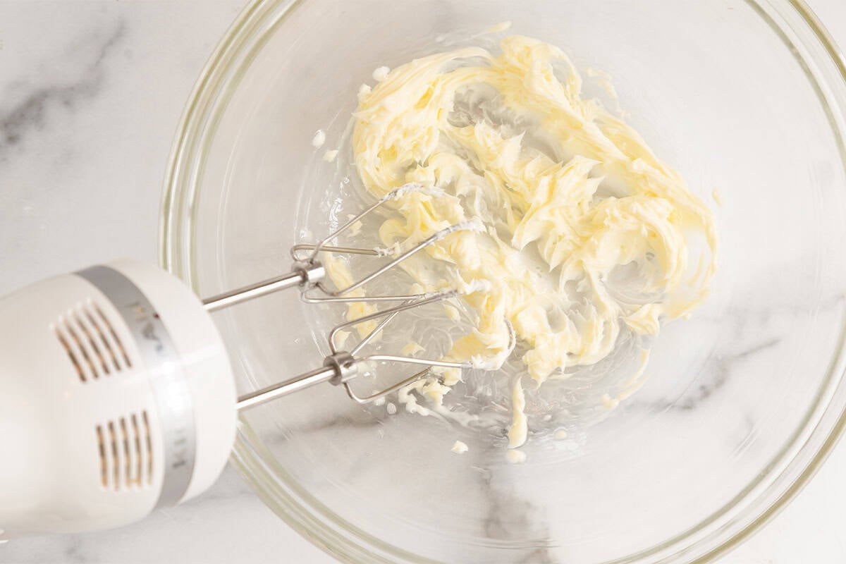 Butter in bowl with mixer for cranberry cookies.