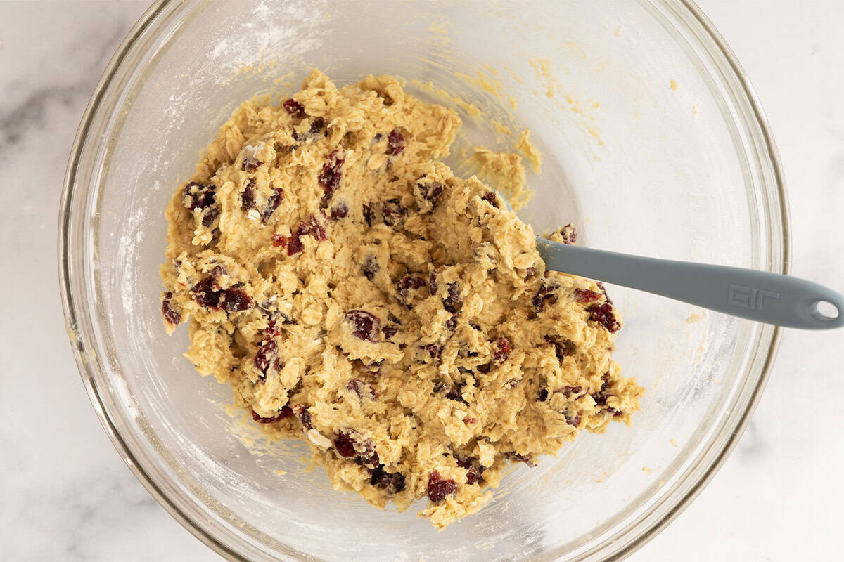 Dough for cranberry cookies in glass bowl.