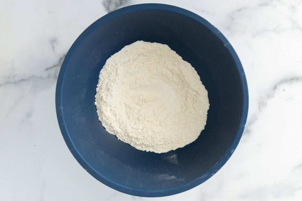 dry ingredients for apple cake in blue bowl.