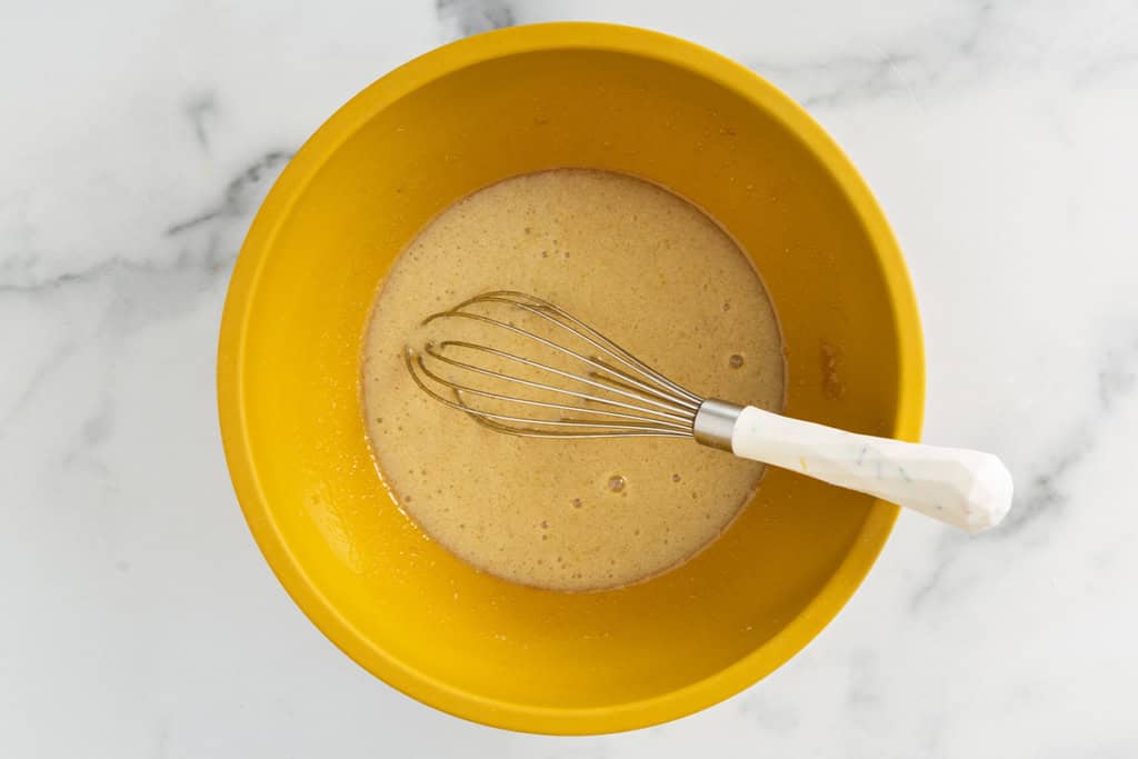 wet ingredients for apple cake in yellow bowl.