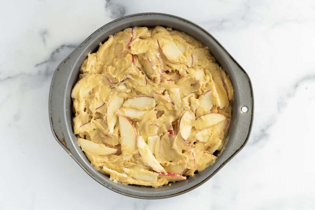 batter for apple cake in metal pan.