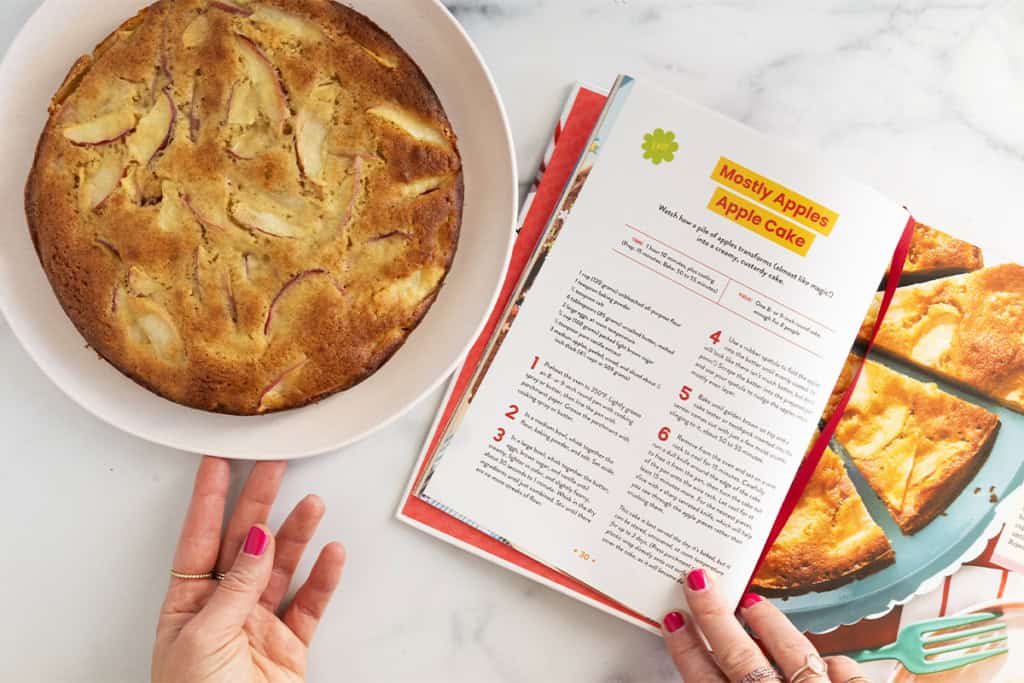 easy apple cake on plate with cookbook.