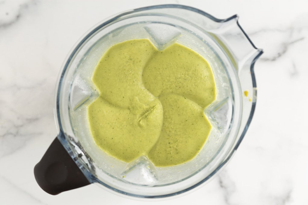 Broccoli cheddar soup being pureed in blender.