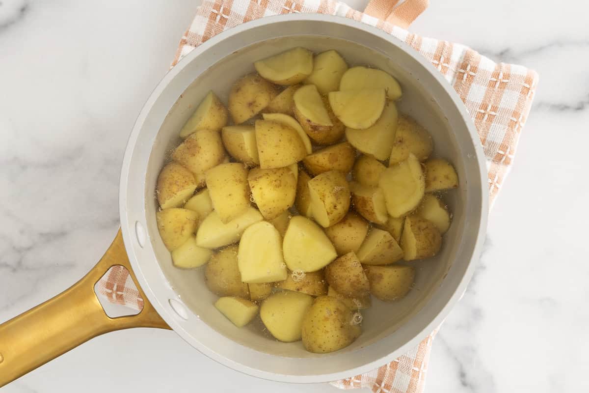 Potatoes in pot with water for mashed potatoes with broccoli.