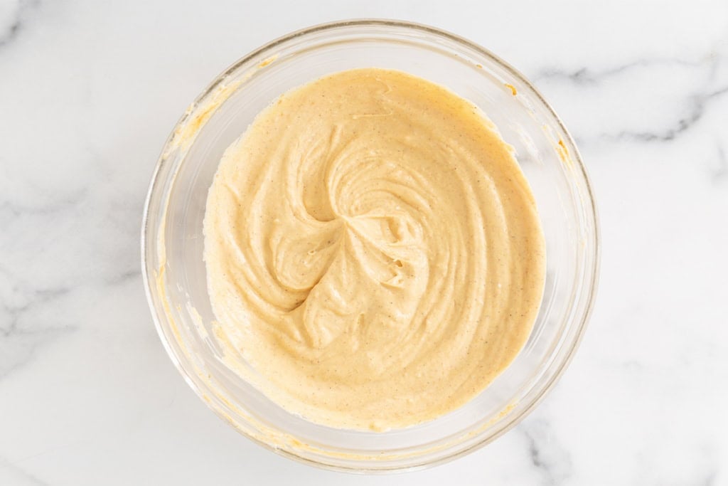 Batter for pumpkin cheesecake in glass bowl.