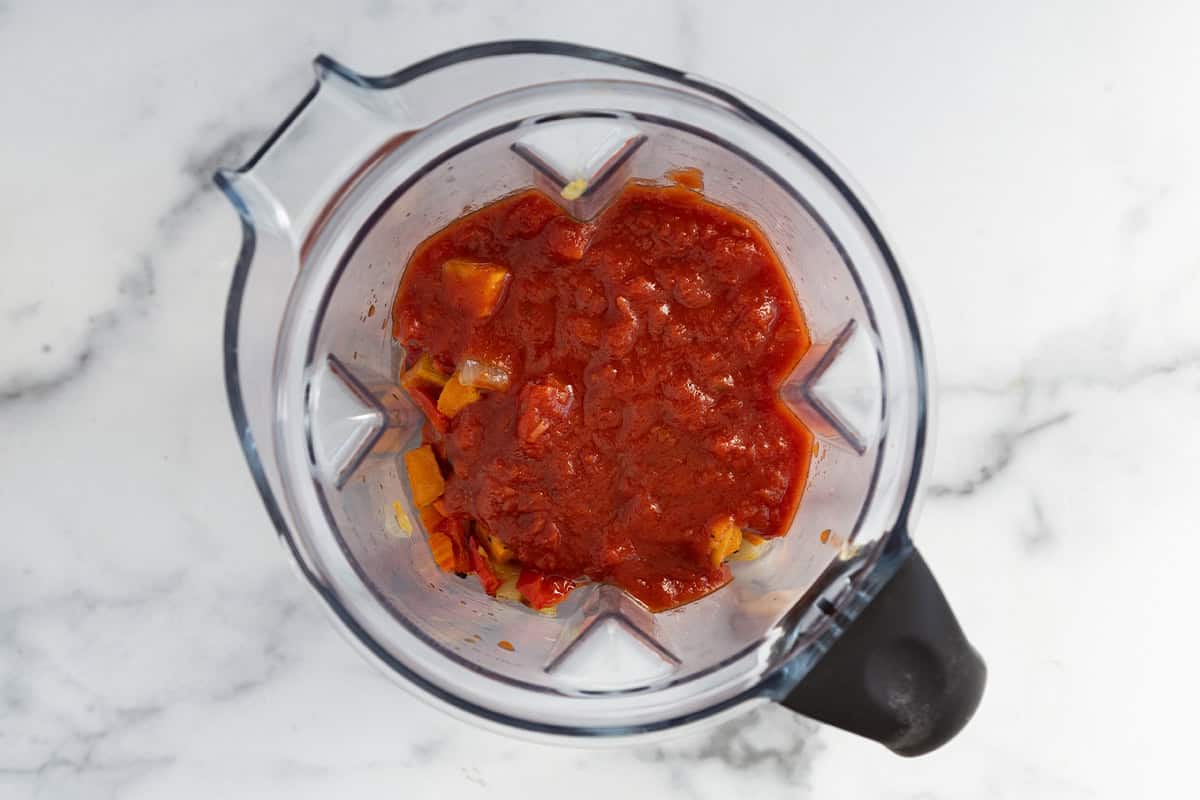 Roasted veggies and tomato sauce in blender for roasted vegetable pasta sauce.