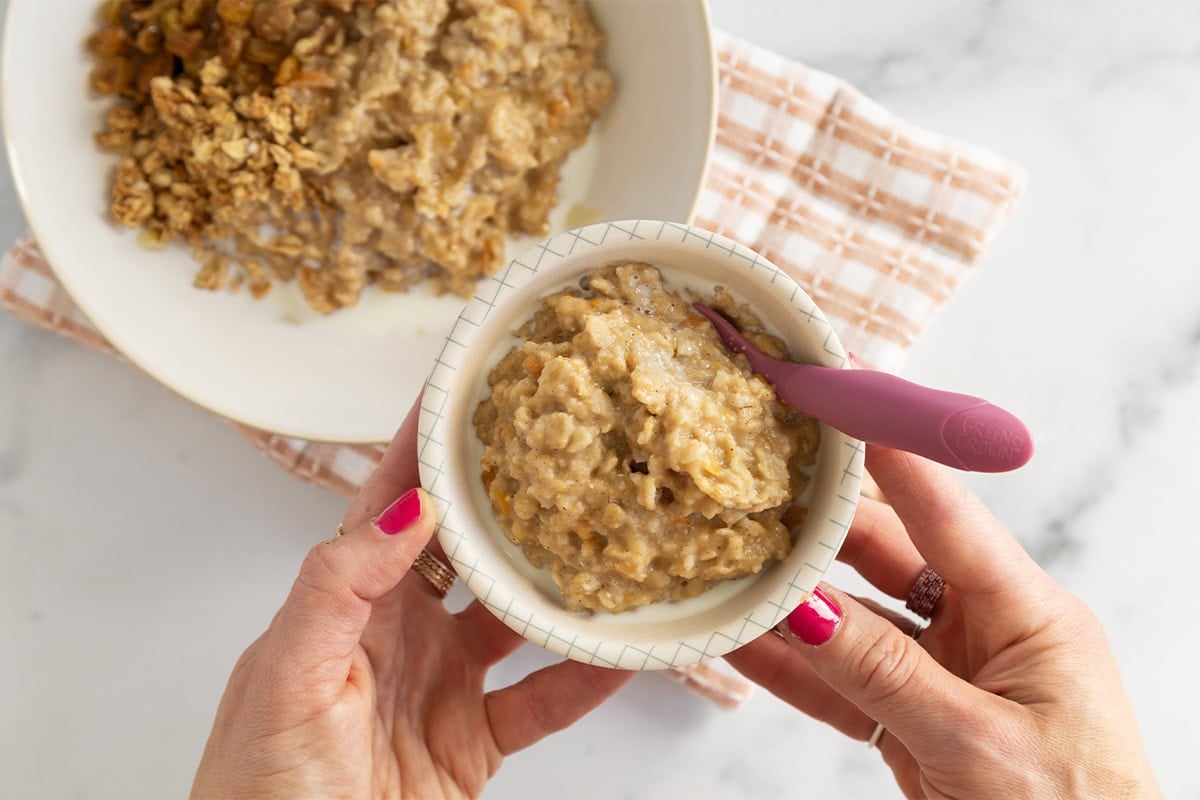 Hands holding bowl of sweet potato oatmeal.