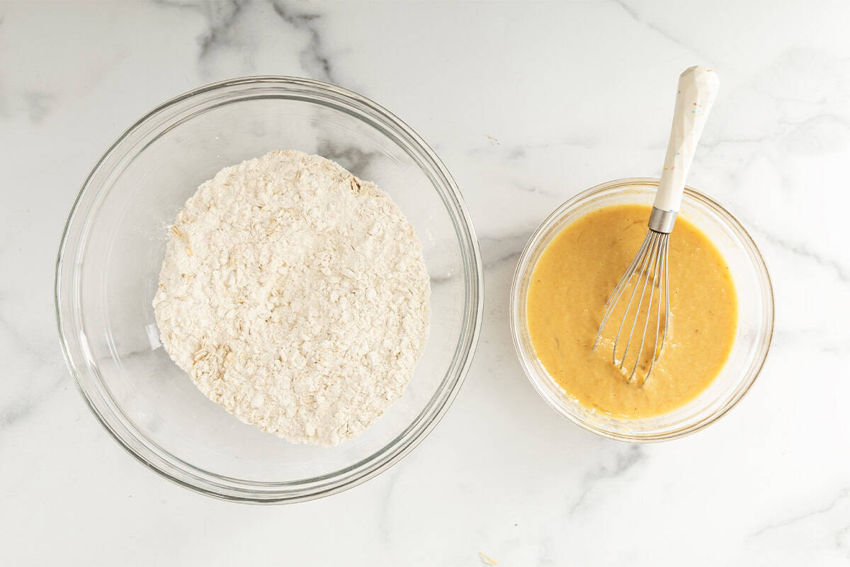 Wet and dry ingredients for apple oatmeal pancakes in two glass bowls.